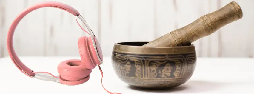 Picture of pink headphones next to a Tibetan singing bowl