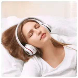 Woman relaxing in bed listening to a virtual sound bath with headphones